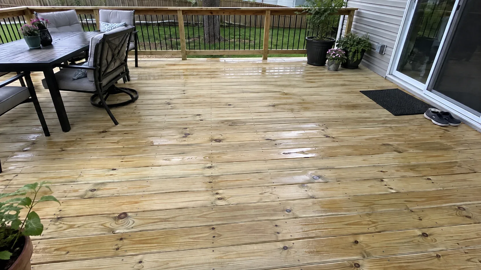 Newly fixed treated boards showing knots, a greenish chemical tinge and neat rows of sunken screws, with a tape measure resting at the edge